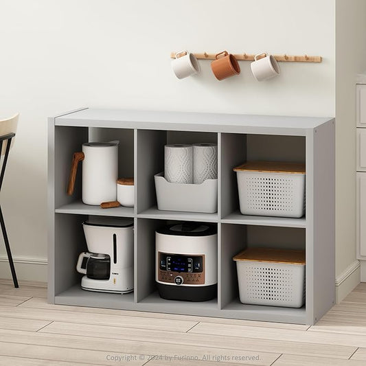 Gray storage cabinet with kitchen appliances and items on a light wooden floor.